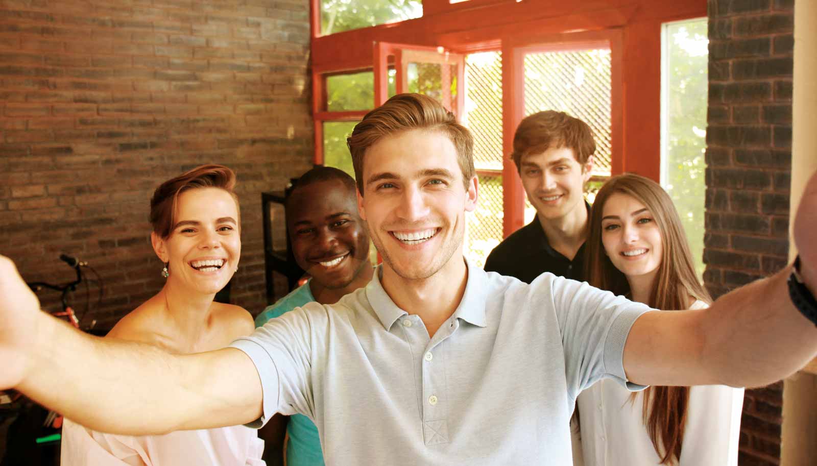 Motiv: fröhliche Gruppe junger Männer und Frauen macht ein Selfie